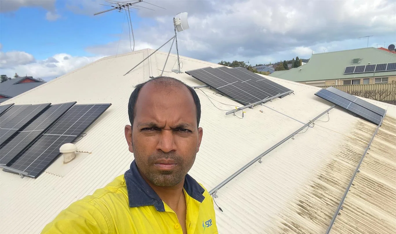Solar installation worker on site beside residential solar panels, project photo 01