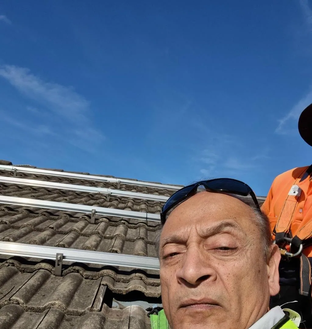Solar installation worker on site beside residential solar panels, project photo 03