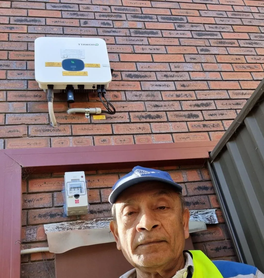 Solar installation worker on site beside residential solar panels, project photo 30